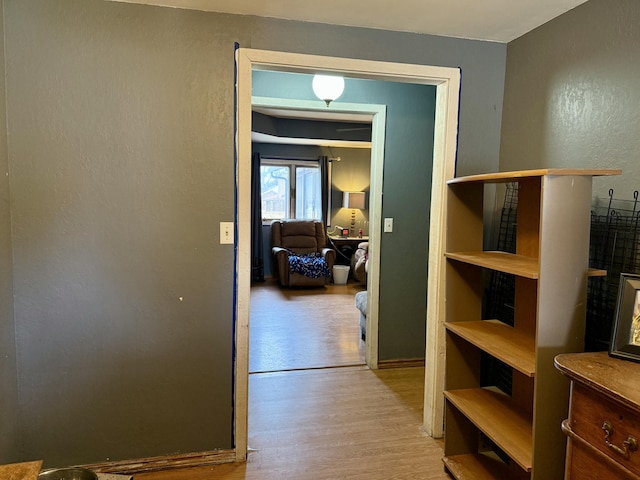 hallway featuring a textured wall and wood finished floors