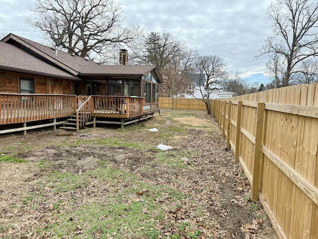 view of yard featuring a sunroom, a fenced backyard, and a wooden deck