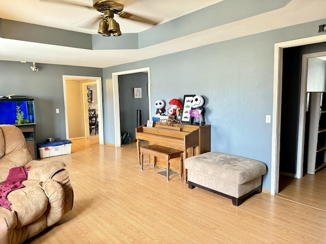 living room with light wood-type flooring and a ceiling fan