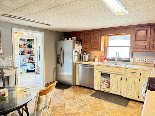 kitchen featuring visible vents, stainless steel appliances, a sink, and light countertops