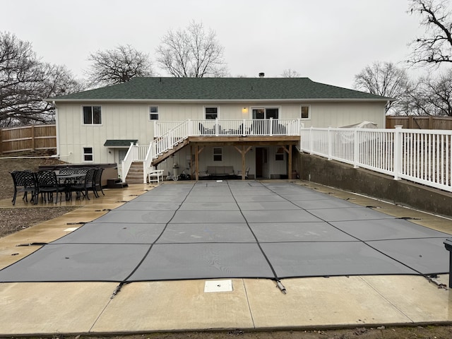 rear view of house with roof with shingles, a patio, fence, a wooden deck, and stairs