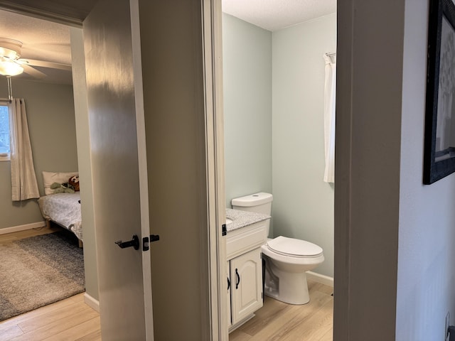 bathroom featuring vanity, wood finished floors, toilet, and baseboards