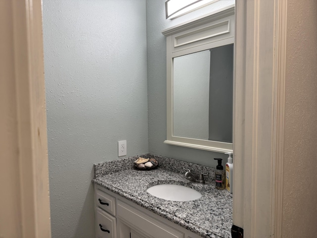 bathroom featuring a textured wall and vanity