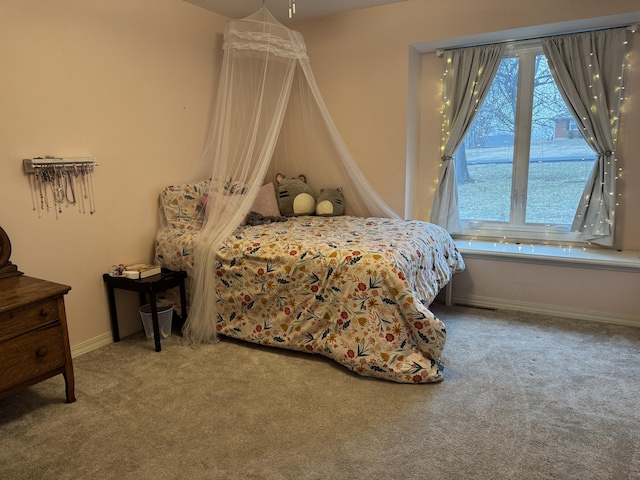 carpeted bedroom with multiple windows and baseboards