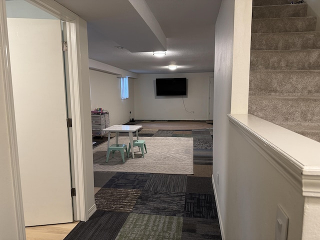 hallway with stairway, wood finished floors, and baseboards