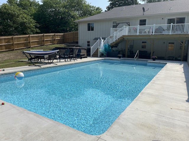 view of pool with a fenced in pool, a patio, stairway, fence, and a wooden deck