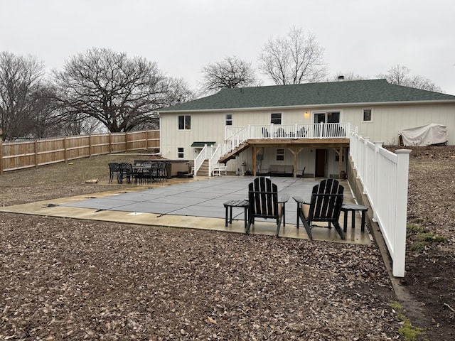 rear view of property with roof with shingles, a patio, stairway, a deck, and a fenced backyard