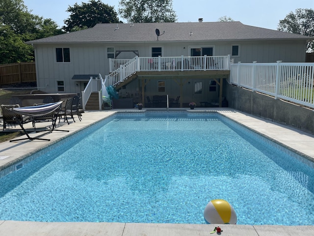 view of swimming pool featuring a fenced in pool, a patio, stairs, fence, and a wooden deck