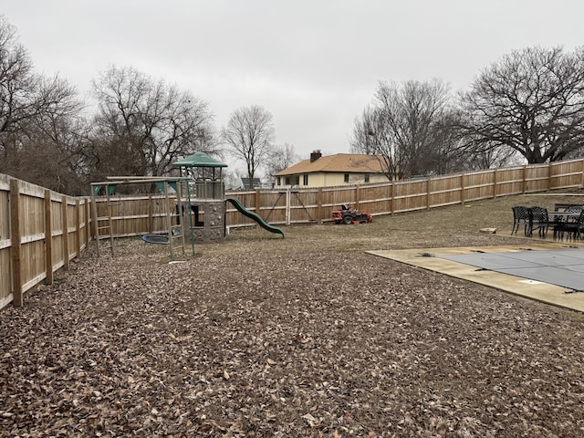 view of yard featuring a fenced backyard and a playground