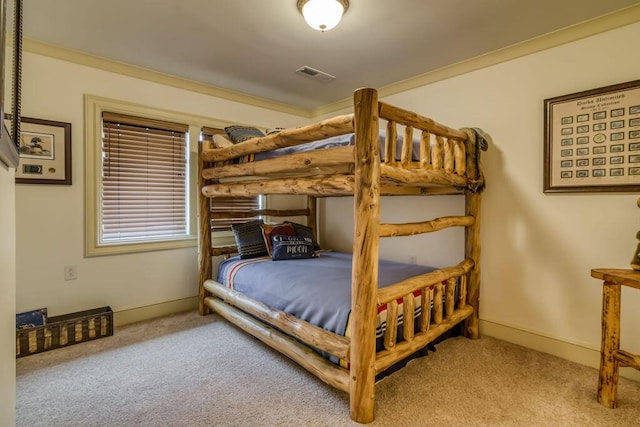 carpeted bedroom with visible vents, crown molding, and baseboards