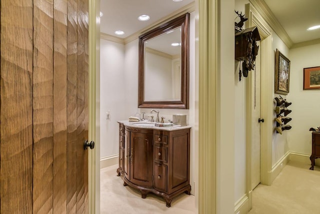 bathroom with recessed lighting, baseboards, crown molding, and vanity