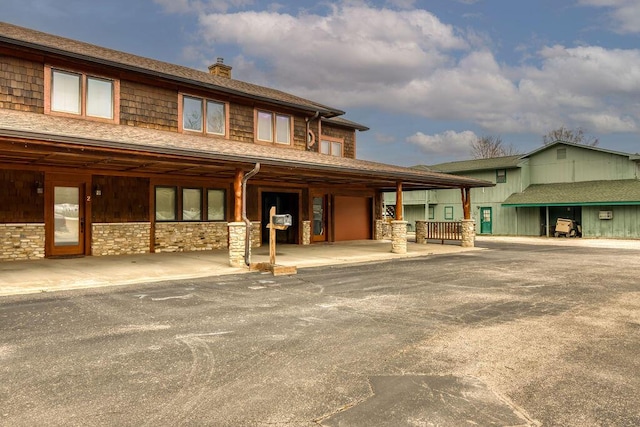 exterior space with stone siding and a chimney