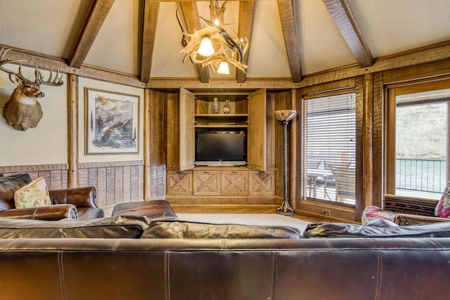 living area with built in features and vaulted ceiling with beams