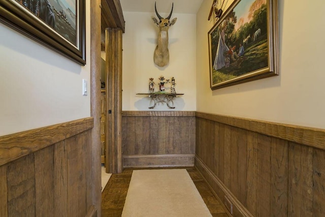 doorway with wooden walls and wainscoting