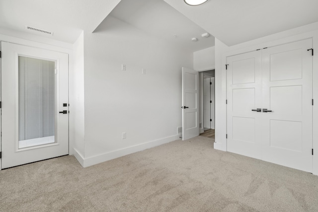 unfurnished bedroom featuring a closet, carpet, visible vents, and baseboards