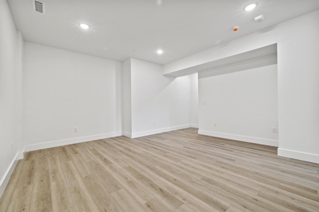 finished basement featuring baseboards, light wood-style flooring, visible vents, and recessed lighting