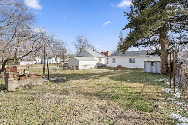 view of yard with an outbuilding, a garden, fence, and a storage unit