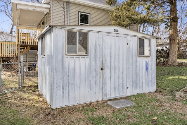 view of shed featuring stairway, fence, and a gate