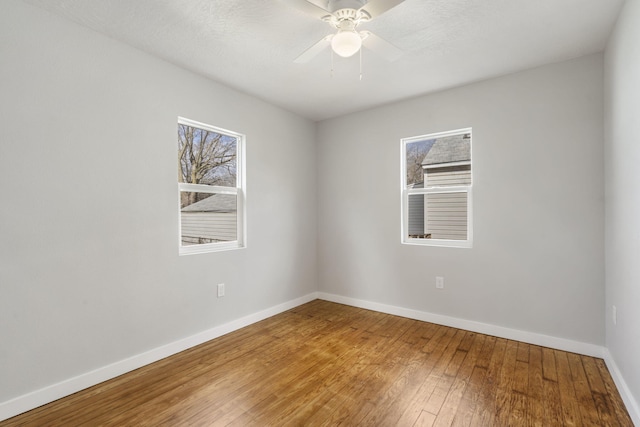 unfurnished room featuring baseboards, ceiling fan, and hardwood / wood-style floors