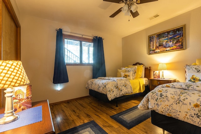 bedroom featuring ceiling fan, wood-type flooring, visible vents, and baseboards