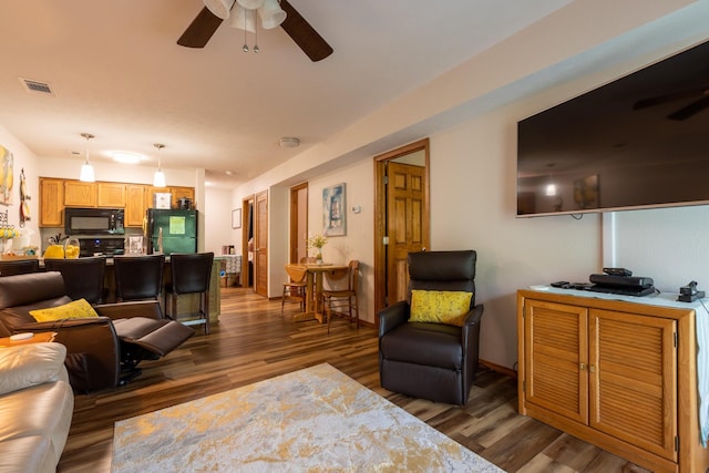 living area with ceiling fan, wood finished floors, and visible vents