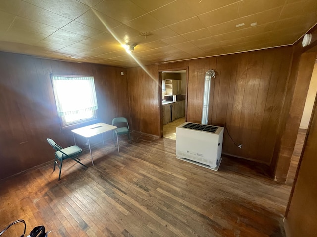 interior space featuring wood-type flooring, wood walls, and heating unit