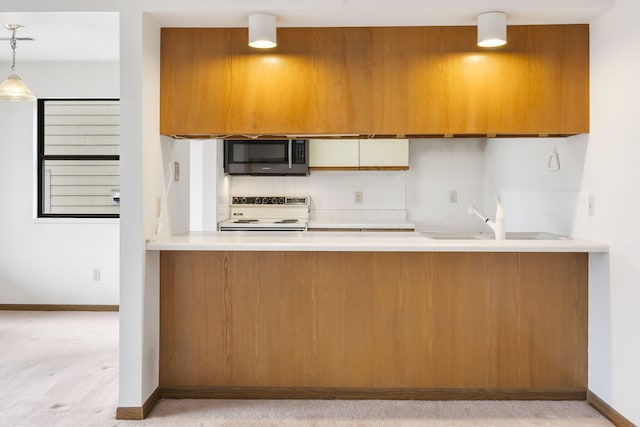 kitchen with stainless steel microwave, a sink, electric range, and a peninsula