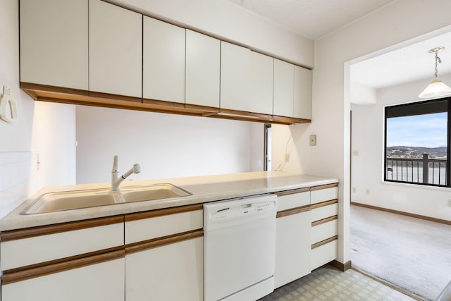 kitchen with white dishwasher, light countertops, light floors, white cabinetry, and a sink