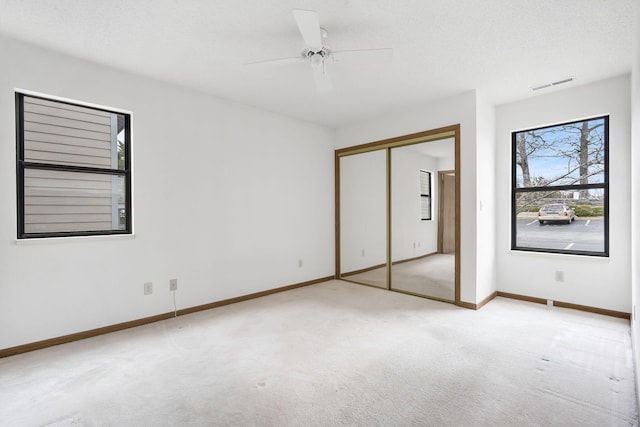 unfurnished bedroom featuring baseboards, visible vents, a textured ceiling, carpet flooring, and a closet