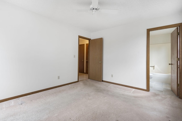 spare room with a ceiling fan, light carpet, and baseboards