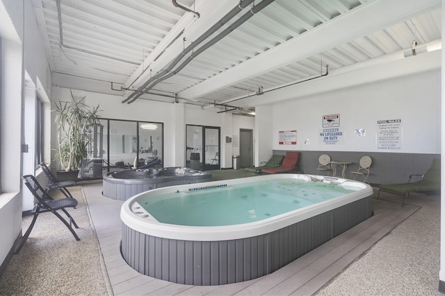 view of swimming pool with an indoor hot tub