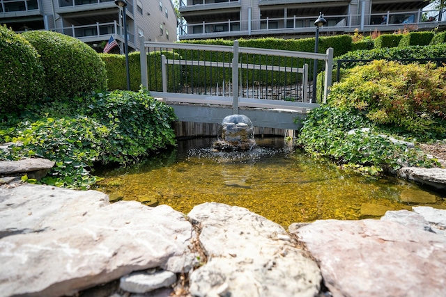 view of yard featuring fence and a garden pond