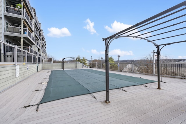 view of swimming pool with fence and a pergola