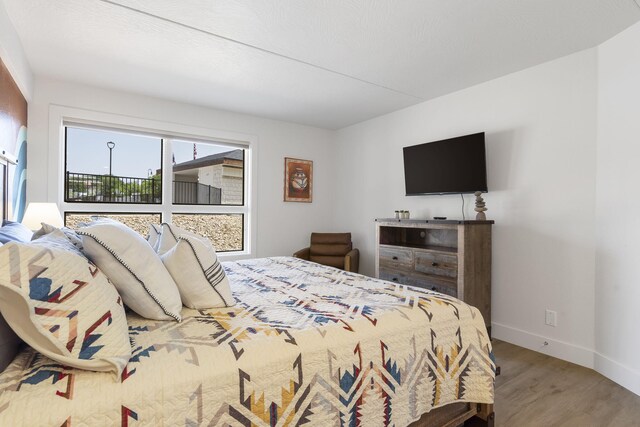 bedroom with baseboards and wood finished floors