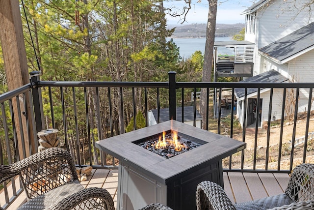 balcony with an outdoor fire pit and a water view