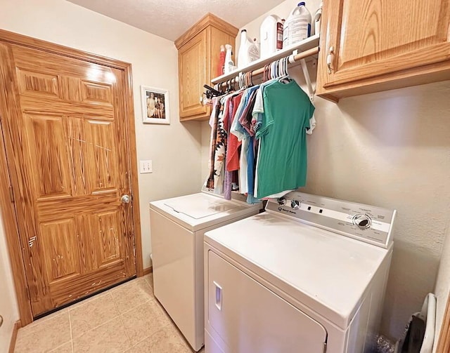 washroom with light tile patterned floors, separate washer and dryer, and cabinet space