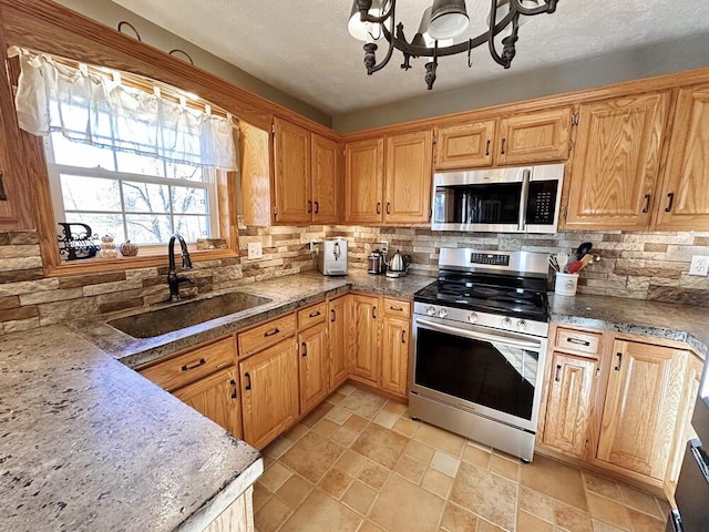 kitchen with tasteful backsplash, a textured ceiling, stainless steel appliances, and a sink