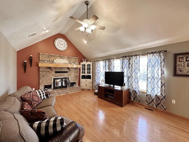 living room with lofted ceiling, a ceiling fan, visible vents, and light wood-style floors