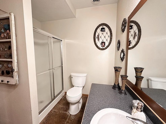 full bath featuring a sink, a shower stall, and toilet