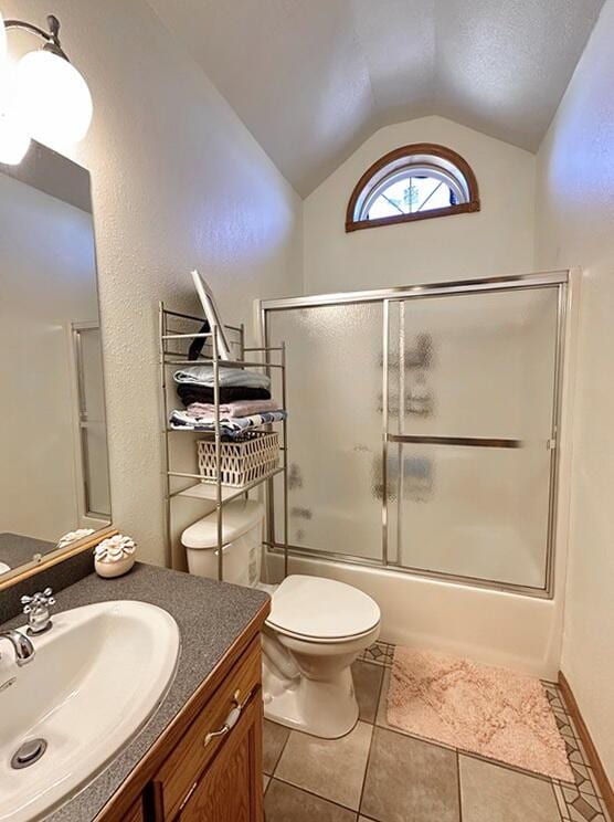 bathroom with bath / shower combo with glass door, lofted ceiling, toilet, tile patterned floors, and vanity