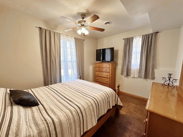 bedroom featuring a ceiling fan, visible vents, and baseboards