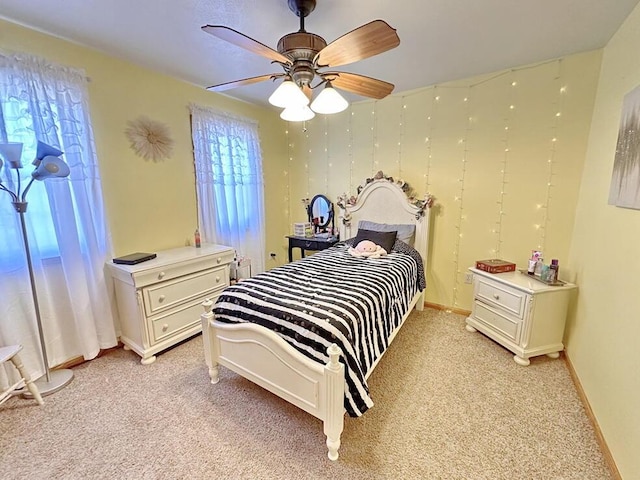 bedroom featuring baseboards, multiple windows, and light colored carpet