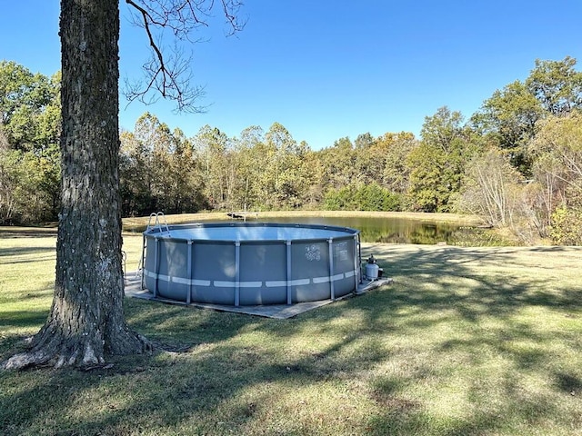 outdoor pool featuring a yard and a forest view