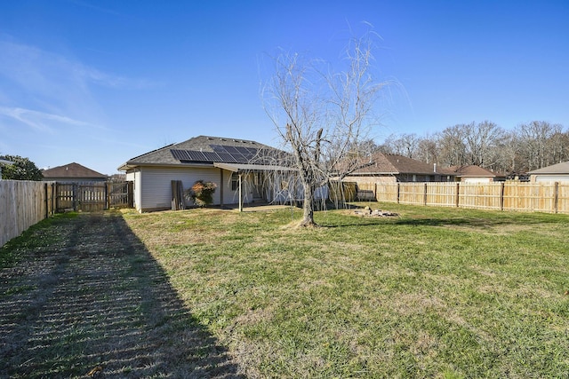 view of yard with a fenced backyard and a gate