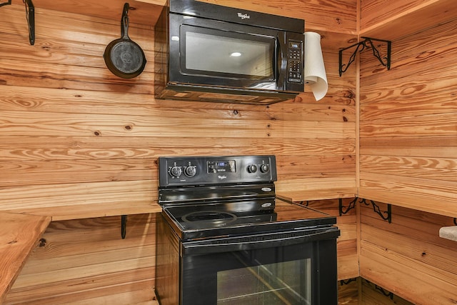 kitchen featuring black appliances, butcher block counters, and wood walls