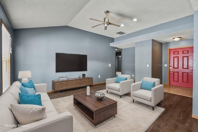 living area with visible vents, ceiling fan, vaulted ceiling, wood finished floors, and baseboards