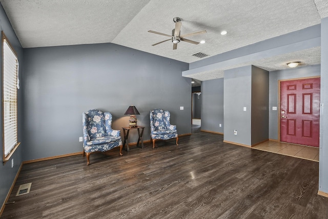 sitting room with visible vents, vaulted ceiling, a textured ceiling, and wood finished floors