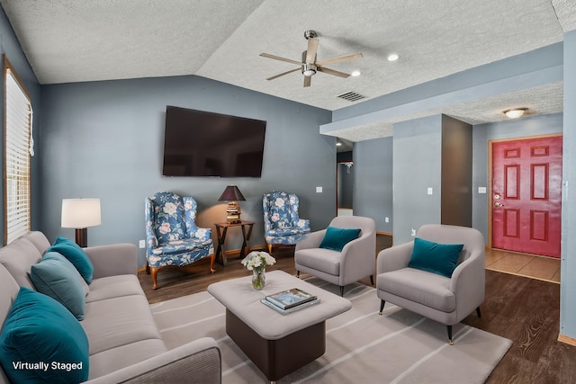 living area featuring lofted ceiling, a textured ceiling, wood finished floors, and visible vents