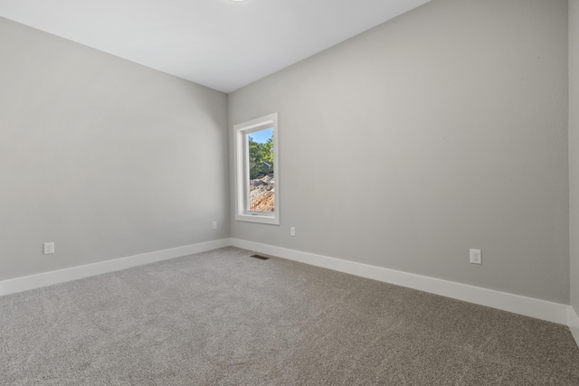 unfurnished room featuring carpet floors, visible vents, and baseboards