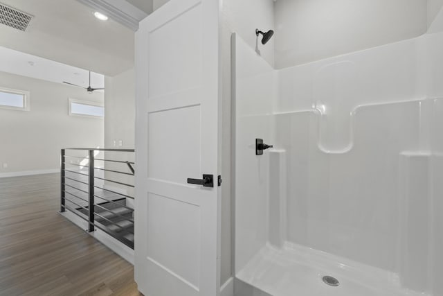 full bath featuring a walk in shower, wood finished floors, a ceiling fan, visible vents, and baseboards